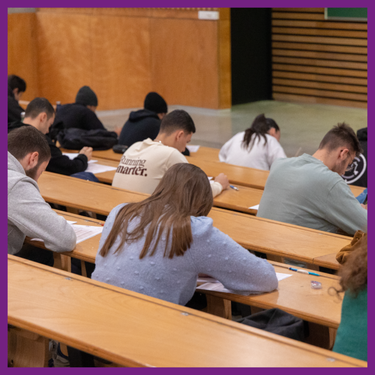 Des étudiants sont assis dans un amphithéâtre et passent le Score IAE Message, test de sélection porté par la Fondation Nationale pour l'Enseignement de la Gestion des Entreprises (FNEGE).