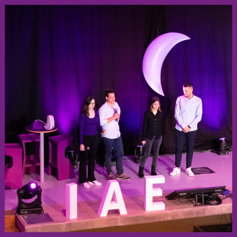 Des étudiants de l'IAE Limoges sont sur scène et présentent leur projet devant un amphithéâtre rempli avec du public.