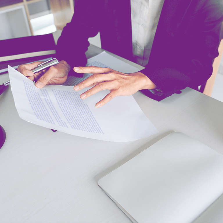 Professionnel en costume examinant un document juridique sur un bureau, illustrant les compétences requises dans le domaine du mandat judiciaire.